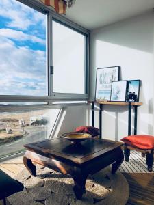 sala de estar con mesa y ventana grande en STUDIO FACE MER PORNICHET – VUE BAIE DE LA BAULE en Pornichet