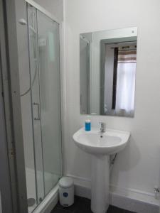 a white bathroom with a sink and a shower at Villa Anson in Manchester