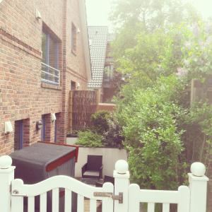 a white picket fence in front of a house at Duenenschloss in Westerland (Sylt) +2 photos