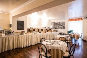 a restaurant with tables and chairs and a buffet at Grand Hotel Italia in Orvieto