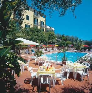 a group of tables and chairs next to a pool at Residence Elvira in Diano Marina
