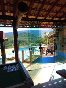 a room with a pool and a large glass window at Bistrô Pousada Savacipó in Serra do Cipo