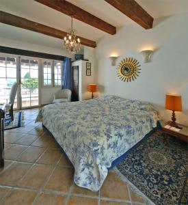 a bedroom with a large bed and a chandelier at Le Hameau in Saint-Paul-de-Vence