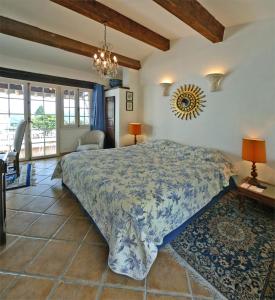 a bedroom with a large bed and a chandelier at Le Hameau in Saint Paul de Vence