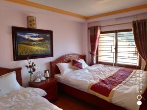 a bedroom with two beds and a window at Quoc Thai Sapa Hotel in Sa Pa