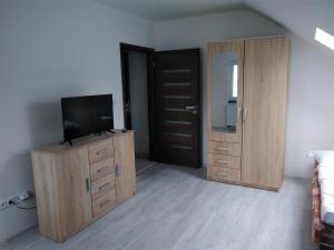 a bedroom with a television on a dresser and a door at Vinotéka "U Kozů" in Nové Město nad Metují