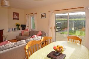 ein Wohnzimmer mit einem Sofa und einem Tisch mit Obst darauf in der Unterkunft Cottage 323 - Cleggan in Cleggan