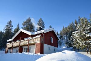 ein Blockhaus im Schnee mit Bäumen in der Unterkunft Bjursås Berg & Sjö in Bjursås