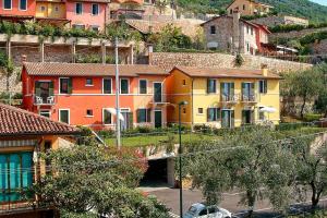 un gruppo di case sul fianco di una collina di Aparthotel La Caletta Bolognese a Brenzone sul Garda