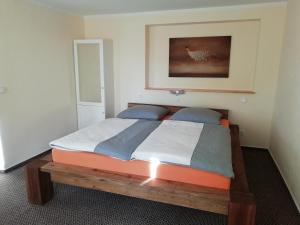 ein Schlafzimmer mit einem Holzbett in einem Zimmer in der Unterkunft Pension Altwahnsdorf in Radebeul