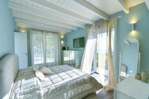 a bedroom with a bed and a large window at Tenuta C'est la Vie in Ischia