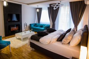 a large bed in a living room with a blue couch at Apartment Exclusive and Studio in Subotica