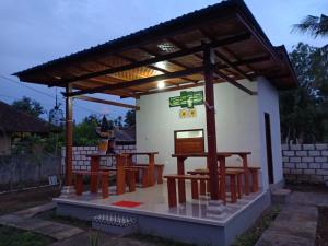a small restaurant with tables and a roof at Santhi Guna Bungalow in Nusa Penida