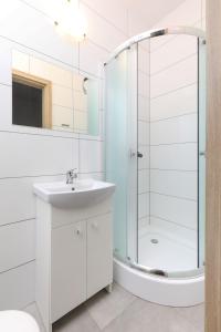 a white bathroom with a sink and a shower at DG Albatros II in Rewal