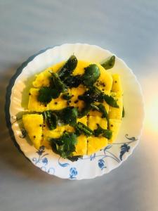 a plate of food with pineapple and greens on it at Wow Rooms 4 You in Jabalpur