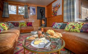 una sala de estar con sofá y mesa con comida. en Chalet Ananas, Hameau des Marmottes en Les Menuires