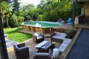 um quintal com uma piscina e um deque com cadeiras e uma mesa em VILLA SAINT VINCENT em Agen