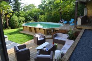 a backyard with a pool and a deck with chairs and a table at VILLA SAINT VINCENT in Agen