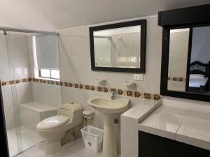 a white bathroom with a toilet and a sink at Casa Girardot Condominio El peñon 5 Habitaciones. in Girardot +28 photos