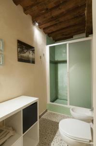 a bathroom with a toilet and a glass shower at Il nido nascosto in Lucca