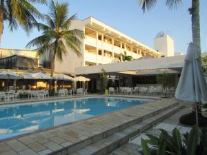 
a hotel room with a pool and a balcony at Ubatuba Palace Hotel in Ubatuba
