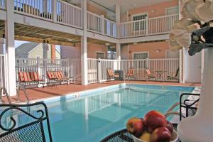 a pool with chairs and a bowl of fruit on a table at Monte Carlo Condos Ocean City in Ocean City