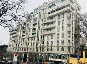 Un gran edificio blanco con coches aparcados delante. en 2 Bedrooom In CENTER Всегда есть свет !, en Odessa