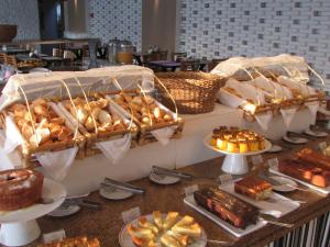 a table topped with lots of different types of bread at Ubatuba Palace Hotel in Ubatuba