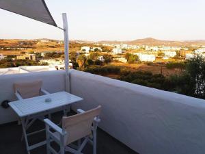 einen Tisch und Stühle auf dem Balkon eines Hauses in der Unterkunft Thalassitra Private Pool Suites & Spa in Adamas