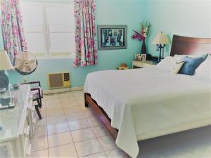 ein Schlafzimmer mit einem großen weißen Bett und einem Fenster in der Unterkunft Opp Sea, Beach, Restaurants 5b - 2bed 2 bath 5B Hastings Tower in Bridgetown
