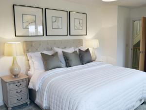 チェルトナムにあるHawthornの白いベッド1台、壁に3枚の絵が飾られたベッドルーム1室