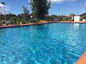 a large swimming pool with blue water at Antigua chiama Italia villas in Jolly Harbour