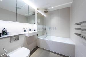 a white bathroom with a tub and a toilet and a sink at Amazing Apartment with Incredible Views (MLG) in London