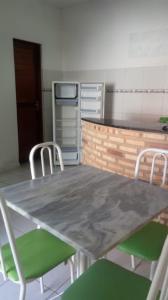 una mesa y sillas en una habitación con cocina en Chalé do Aldo, en Canoa Quebrada