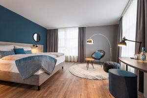 a hotel room with a bed and a desk at HARBR. hotel Heilbronn in Heilbronn