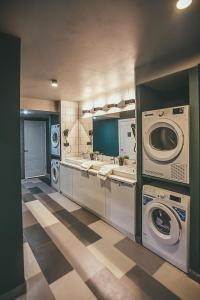 a large laundry room with washing machines and sinks at Hide Hostel in Rostov on Don