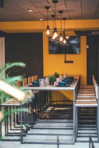 a dining room with a table and chairs and a yellow wall at Hide Hostel in Rostov on Don