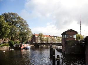 Un río con un puente y barcos en él en SWEETS - Kattenslootbrug en Ámsterdam