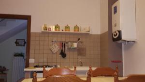 uma cozinha com 2 cadeiras de madeira e uma parede de azulejos em La Castagna Matta em Albareto