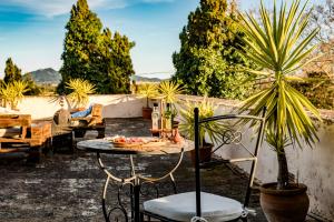 a patio with a table and chairs and plants at Fincahotel Son Valls in Felanitx