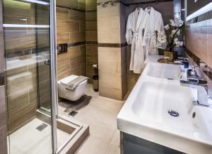 a bathroom with two sinks and a shower and a toilet at Lemar Luxury Apartments in Hersonissos