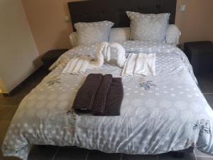 - un lit avec des draps blancs et des serviettes dans l'établissement BAIE DE SOMME - Le pourquoi pas, au Crotoy
