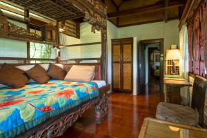 a bedroom with a bed with a colorful comforter at Murni's Houses & Spa in Ubud