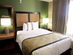 a hotel room with a large bed with two lamps at Extended Stay America Suites - Kansas City - Overland Park - Metcalf Ave in Overland Park