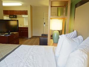 a hotel room with a bed and a television at Extended Stay America Suites - Kansas City - Overland Park - Metcalf Ave in Overland Park