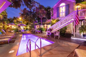 a swimming pool in front of a house at night at Andrews Inn & Garden Cottages in Key West