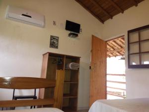 a room with a bed and a desk and a tv at Canto do Riacho Suites in Trindade