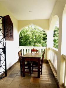 ein Esszimmer mit einem Tisch und einem großen Fenster in der Unterkunft Swahili Oasis in Diani Beach