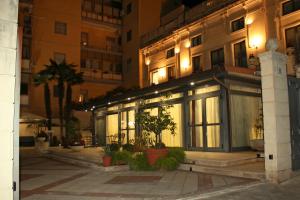 un bâtiment éclairé avec des plantes devant lui dans l'établissement Hotel Villa Cibele, à Catane