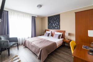 a hotel room with a bed and a chair at Hotel Loco in Lievelde